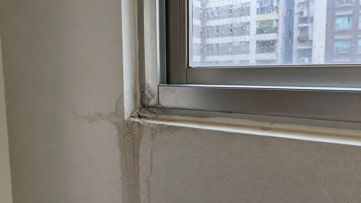 鋁窗下緣與牆面交界出現雨水滲入痕跡的現場照片